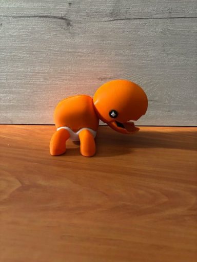 Pokemon Figurita de juguete naranja con una expresión amigable, en posición de arrodillado.